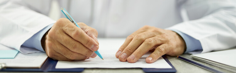 Doctor hands filling in patient medical chart