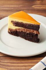 Delicious chocolate cake in white plate on wooden table background