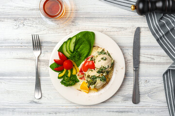 Chicken breast cooked in sauce and fresh vegetables served on plate in cafe