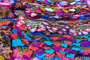 Stack of colorful crochet lace products in woman producer outdoor bazaar in Odemis, Izmir. Many or...