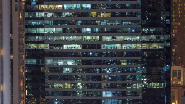 Office buildings windows illuminated at night timelapse. Glass architecture, corporate building at evening with glowing lights