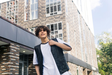 young man on the street against the backdrop of city buildings