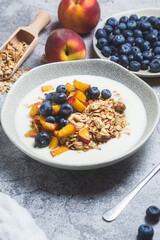 Granola with yogurt, peach, blueberries in a plate 