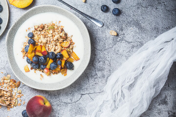 Granola with yogurt, peach, blueberries in a plate 