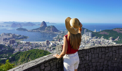Stylish tourist woman on terrace in Rio de Janeiro with the famous Guanabara bay and the cityscape...