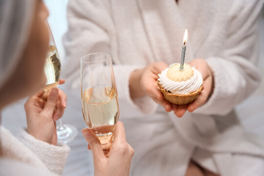 Happy young woman celebrating birthday with her friend