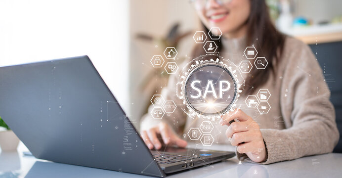 System Applications and Product (SAP). Program helps manage business to access information quickly accurately. Woman using laptop holding magnifying glass with SAP text inside. An icon on background.