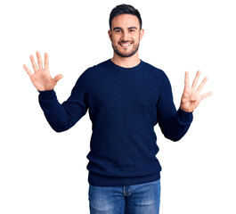 Young handsome man wearing casual clothes showing and pointing up with fingers number nine while...