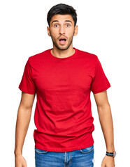 Young handsome man wearing casual red tshirt afraid and shocked with surprise and amazed expression, fear and excited face.