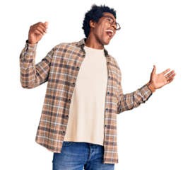 Handsome african american man with afro hair wearing casual clothes and glasses dancing happy and cheerful, smiling moving casual and confident listening to music