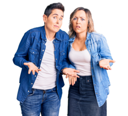 Couple of women wearing casual clothes clueless and confused with open arms, no idea concept.