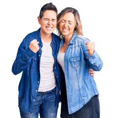 Couple of women wearing casual clothes very happy and excited doing winner gesture with arms raised, smiling and screaming for success. celebration concept.