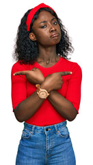 Beautiful african young woman wearing casual clothes pointing to both sides with fingers, different...