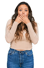 Young hispanic girl wearing casual clothes shocked covering mouth with hands for mistake. secret concept.