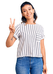 Young woman wearing casual clothes showing and pointing up with fingers number two while smiling confident and happy.