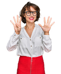Young hispanic woman wearing business style and glasses showing and pointing up with fingers number...