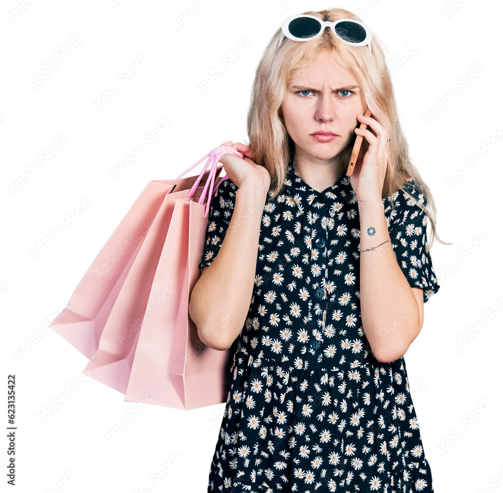 Poster Young caucasian woman holding shopping bags and talking on the smartphone skeptic and nervous, frowning upset because of problem. negative person.