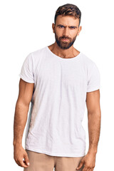 Fototapeta premium Young hispanic man wearing casual white tshirt skeptic and nervous, frowning upset because of problem. negative person.