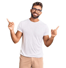 Young hispanic man wearing casual clothes and glasses smiling confident pointing with fingers to different directions. copy space for advertisement