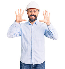 Young handsome man wearing architect hardhat showing and pointing up with fingers number ten while smiling confident and happy.