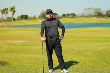 Portrait asian man professinal golf player on golf course. Pro golfer taking a shot