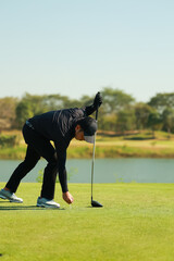 Fototapeta na wymiar Professinal golf player on golf course. Pro golfer taking a shot