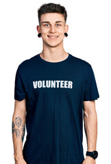 Young caucasian boy with ears dilation wearing volunteer t shirt with a happy and cool smile on face. lucky person.