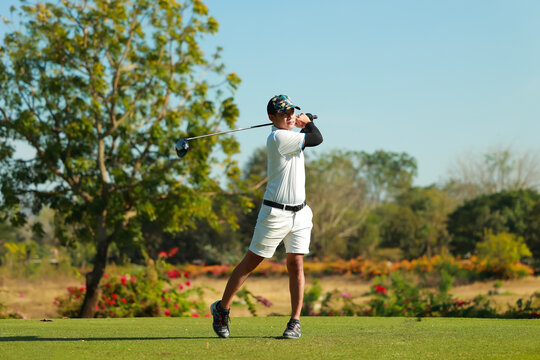 Professinal golf player on golf course. Pro golfer taking a shot