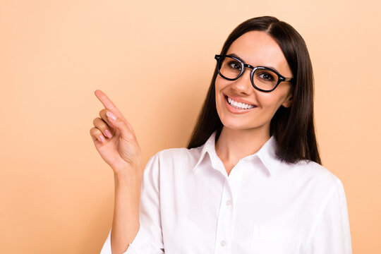 Closeup portrait of young positive promoter businesswoman indicate finger empty space useful tips info isolated on beige color background