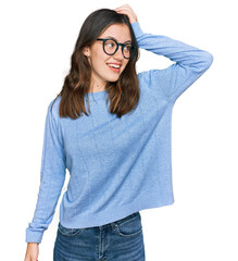Young beautiful woman wearing casual clothes and glasses smiling confident touching hair with hand...