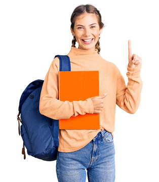 Beautiful caucasian woman with blonde hair wearing student backpack and holding book surprised with an idea or question pointing finger with happy face, number one