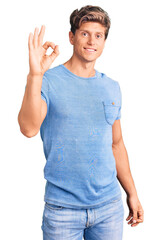 Young handsome man wearing casual clothes smiling positive doing ok sign with hand and fingers. successful expression.