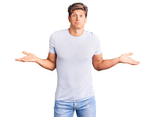 Young handsome man wearing casual clothes clueless and confused expression with arms and hands...