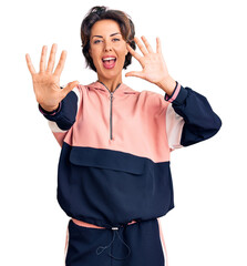 Young beautiful woman wearing sportswear showing and pointing up with fingers number ten while smiling confident and happy.