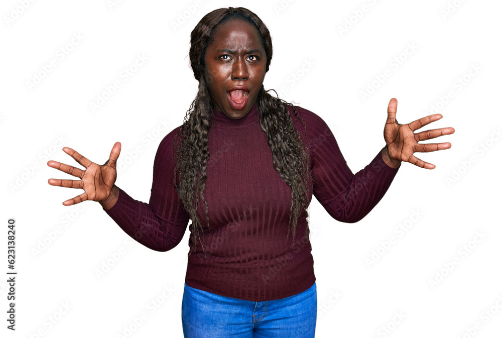 Poster Young african woman wearing casual winter sweater crazy and mad shouting and yelling with aggressive expression and arms raised. frustration concept.