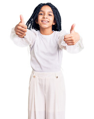 Cute african american girl wearing casual white tshirt approving doing positive gesture with hand, thumbs up smiling and happy for success. winner gesture.