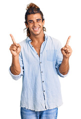 Young hispanic man wearing summer style smiling confident pointing with fingers to different directions. copy space for advertisement