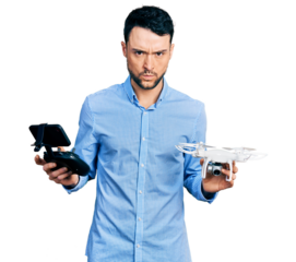 Hispanic man with beard using drone with remote control skeptic and nervous, frowning upset because of problem. negative person.
