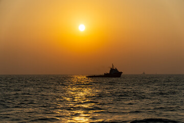 Fototapeta na wymiar sunset creating ship silhouette offshore