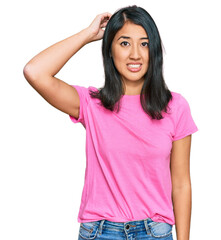 Fototapeta premium Beautiful asian young woman wearing casual pink t shirt confuse and wonder about question. uncertain with doubt, thinking with hand on head. pensive concept.