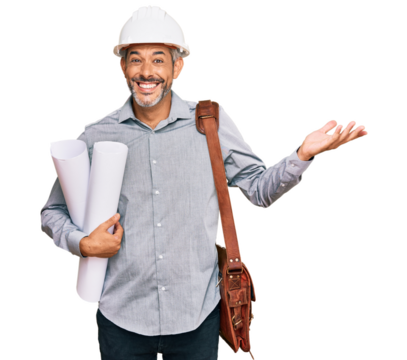 Middle age grey-haired man wearing safety helmet holding blueprints celebrating victory with happy smile and winner expression with raised hands