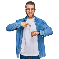 Young caucasian man wearing casual clothes in hurry pointing to watch time, impatience, upset and...
