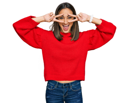 Beautiful brunette woman wearing casual winter sweater doing peace symbol with fingers over face, smiling cheerful showing victory