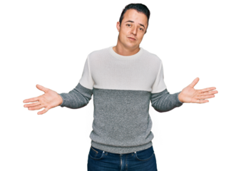 Handsome young man wearing casual winter sweater clueless and confused expression with arms and hands raised. doubt concept.