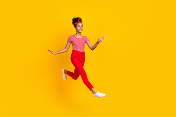 Fototapeta na wymiar Full size photo of funky young girl jumping running elegantly dressed stylish red striped clothes isolated on yellow color background