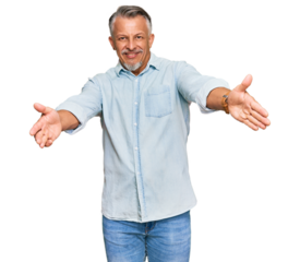 Middle age grey-haired man wearing casual clothes looking at the camera smiling with open arms for hug. cheerful expression embracing happiness.