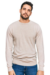 Young hispanic man wearing casual clothes relaxed with serious expression on face. simple and natural looking at the camera.