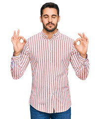Young hispanic man wearing business shirt relax and smiling with eyes closed doing meditation gesture with fingers. yoga concept.