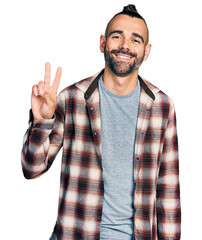 Hispanic man with ponytail wearing casual shirt smiling with happy face winking at the camera doing victory sign. number two. - obrazy, fototapety, plakaty
