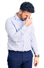 Young hispanic man wearing business clothes tired rubbing nose and eyes feeling fatigue and...